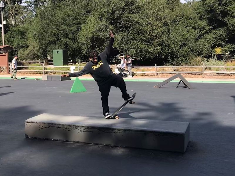 Person performing skateboard trick on block element
