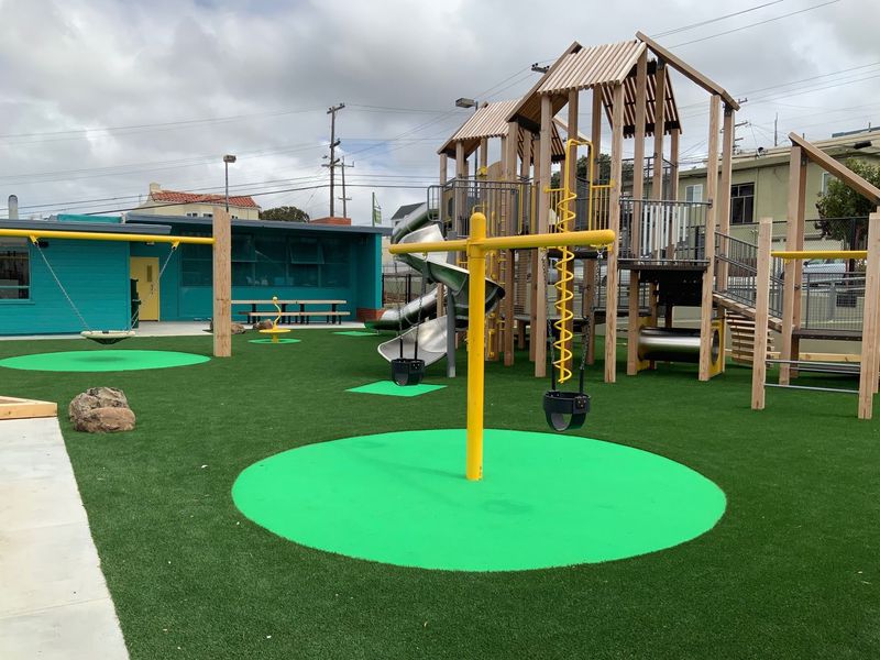 Merced Heights playground north view of the new play structure made out of wood, yellow metal tubing