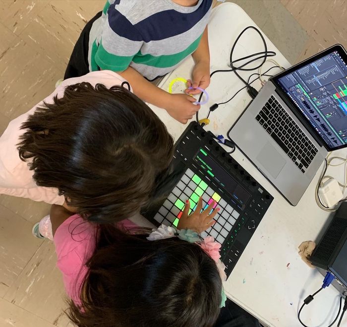 3 batang gumagawa ng musika sa isang laptop