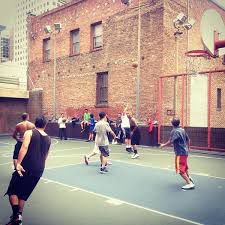 Men playing basketball at Willie “Woo Woo” Wong Playground