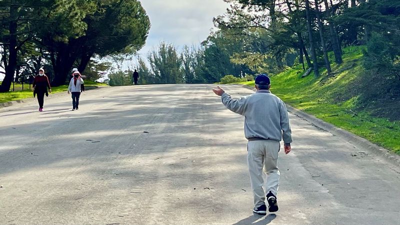 Walkers on John Shelley Drive wave as they approach each other