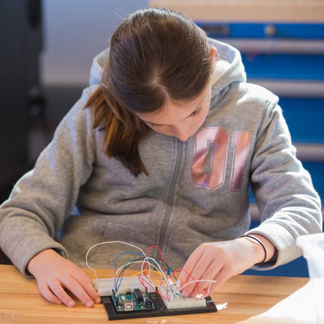 Batang babaeng gumagawa ng proyekto sa elektroniks