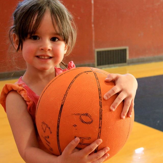 Batang babae na may hawak na bola ng basketbol