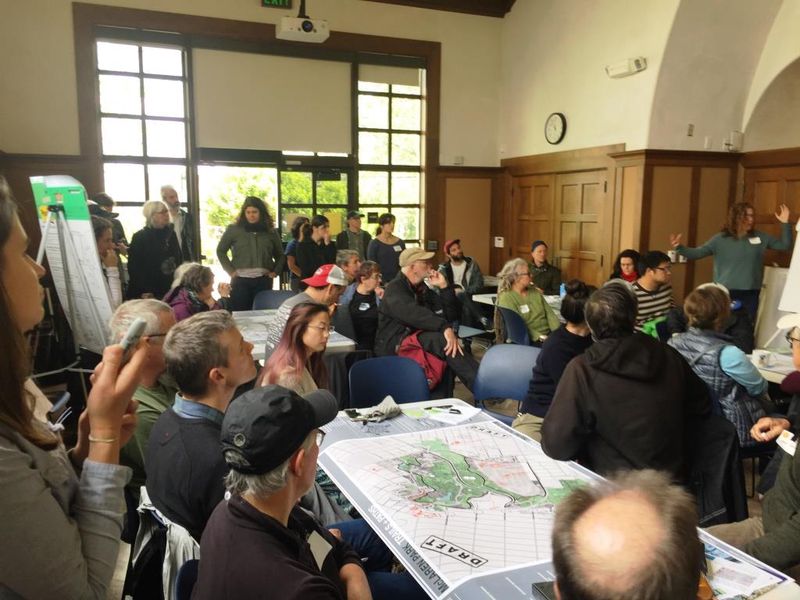 Grupo ng mga Taong Nakaupo sa Ilang Mesa na may mga Mapa