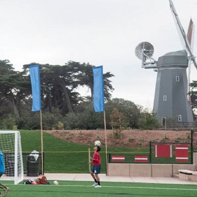 Boy with soccer ball with windmill in background